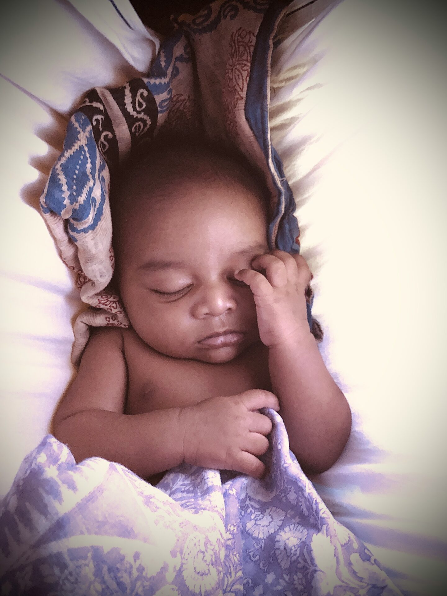 A baby naps while swaddled.