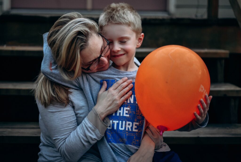 A mother and a son hug.