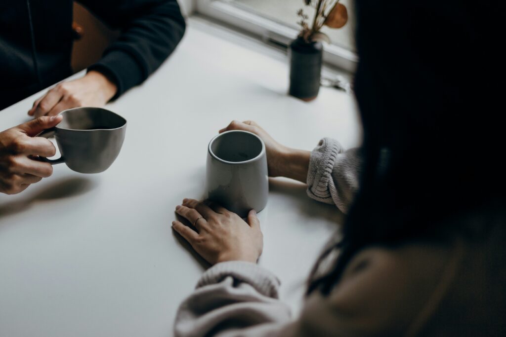 Two people talk over coffee.