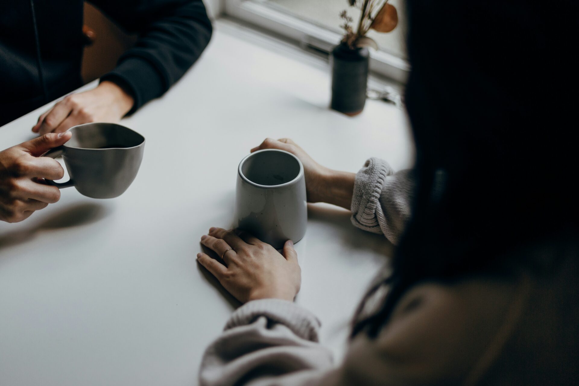 Two people talk over coffee.