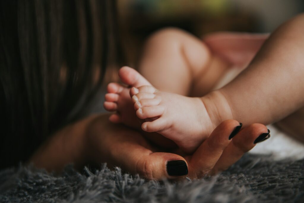 A mother holds her baby's feet.