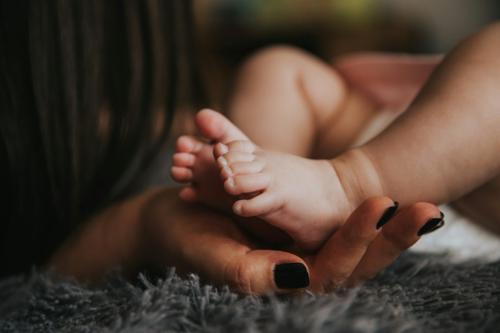 A mother holds her baby's feet.