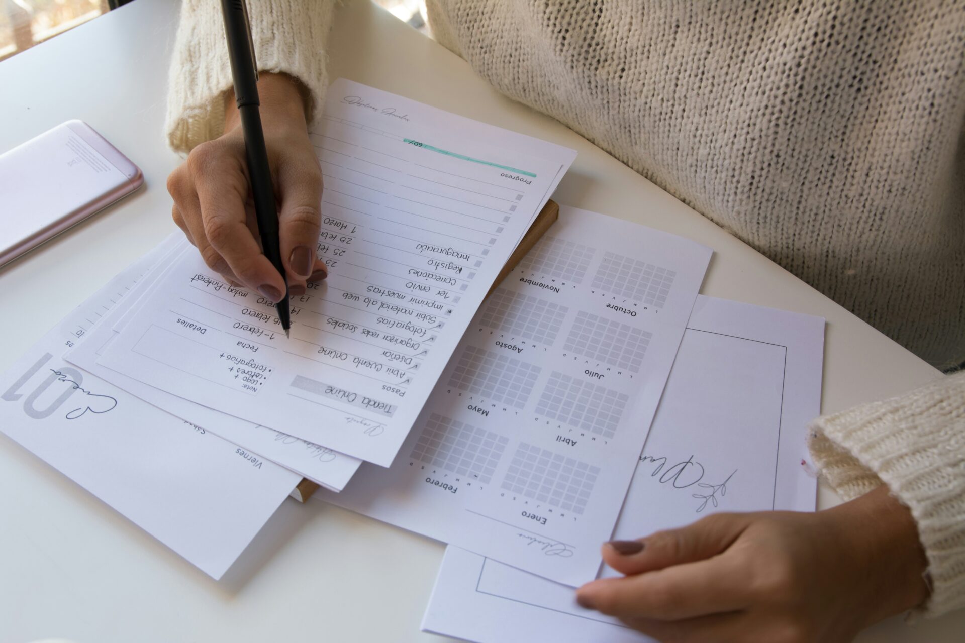 A person writes in a weekly agenda.