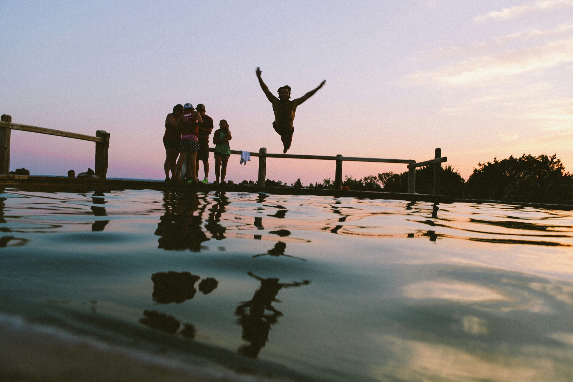 A kid jumps into a lake.