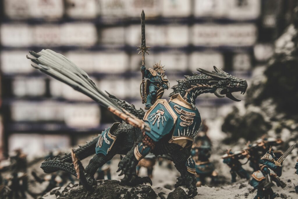 A Dungeons and Dragons knight sits atop a dragon game piece on a table.