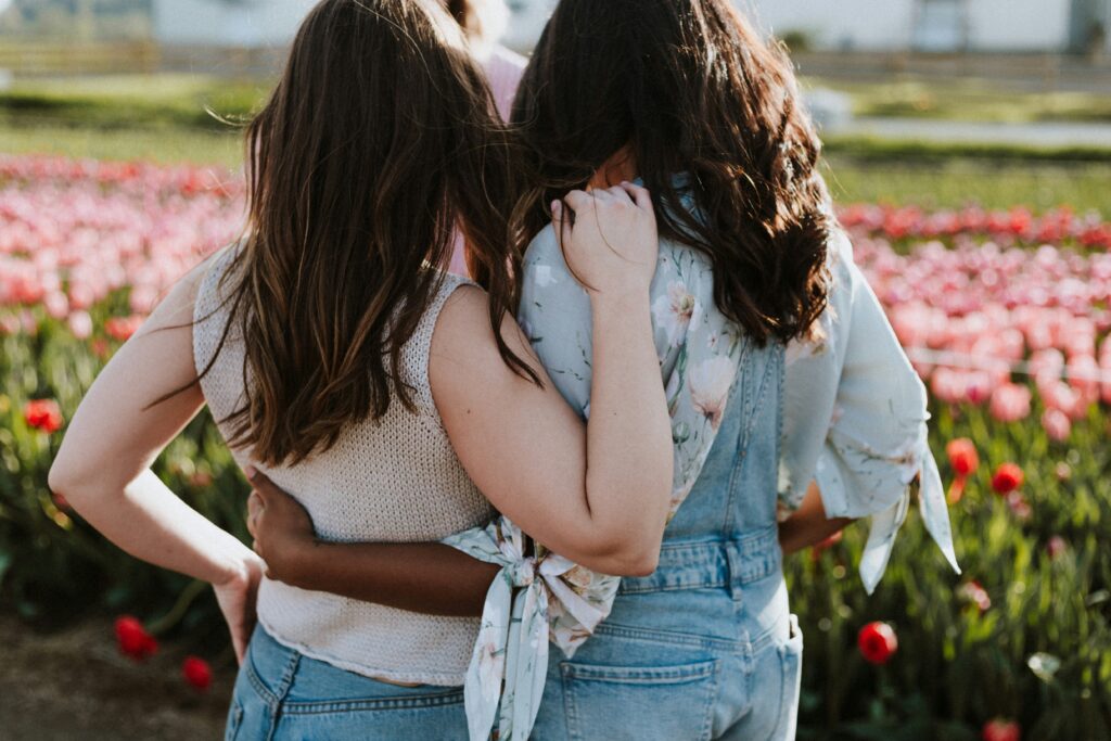 Two friends give each other side hugs.