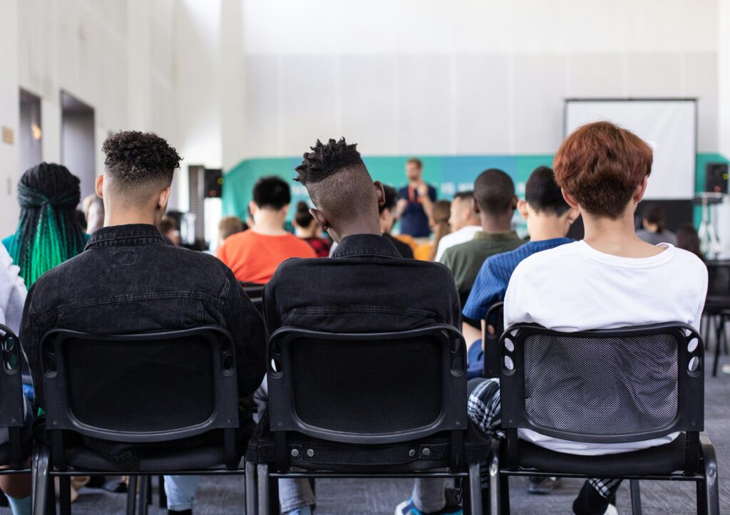 High school students sit in a school assembly.