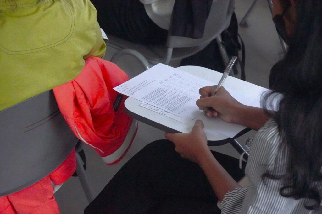 A woman takes notes in class.