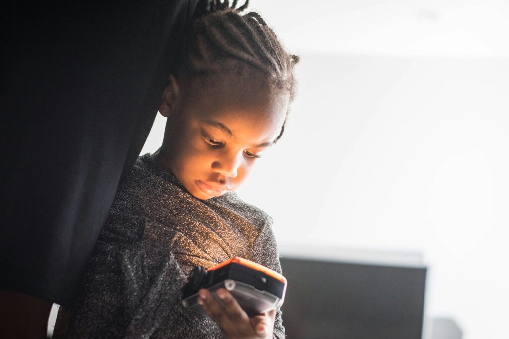 A young child looks at a handheld screen.