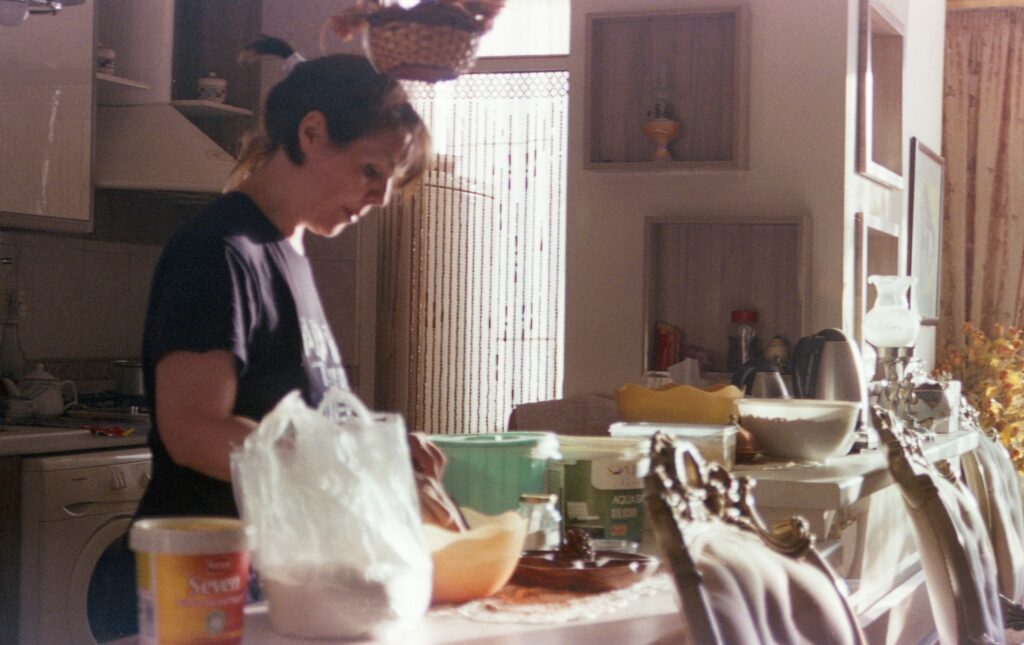 A woman tries to bake in a very messy kitchen.